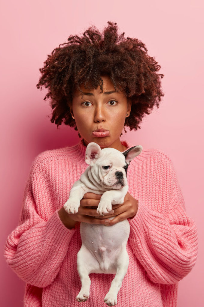 Woman holding a cute puppy. Pet urine from puppies can be damaging to your home.